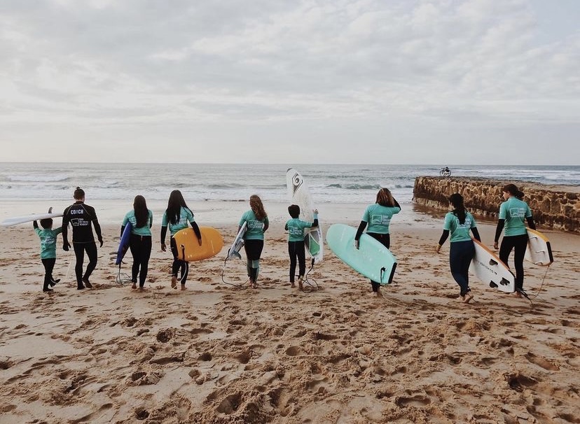 Grupo em aula de surf na praia